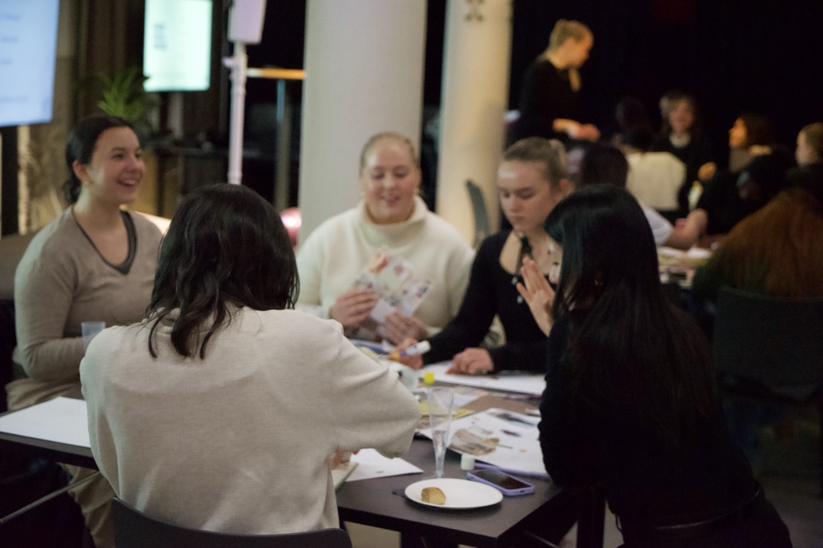 Participants working together around a table at a tmrw. workshop.